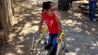 Photo showing Wiliany, leaning on her walking frame and smiling.