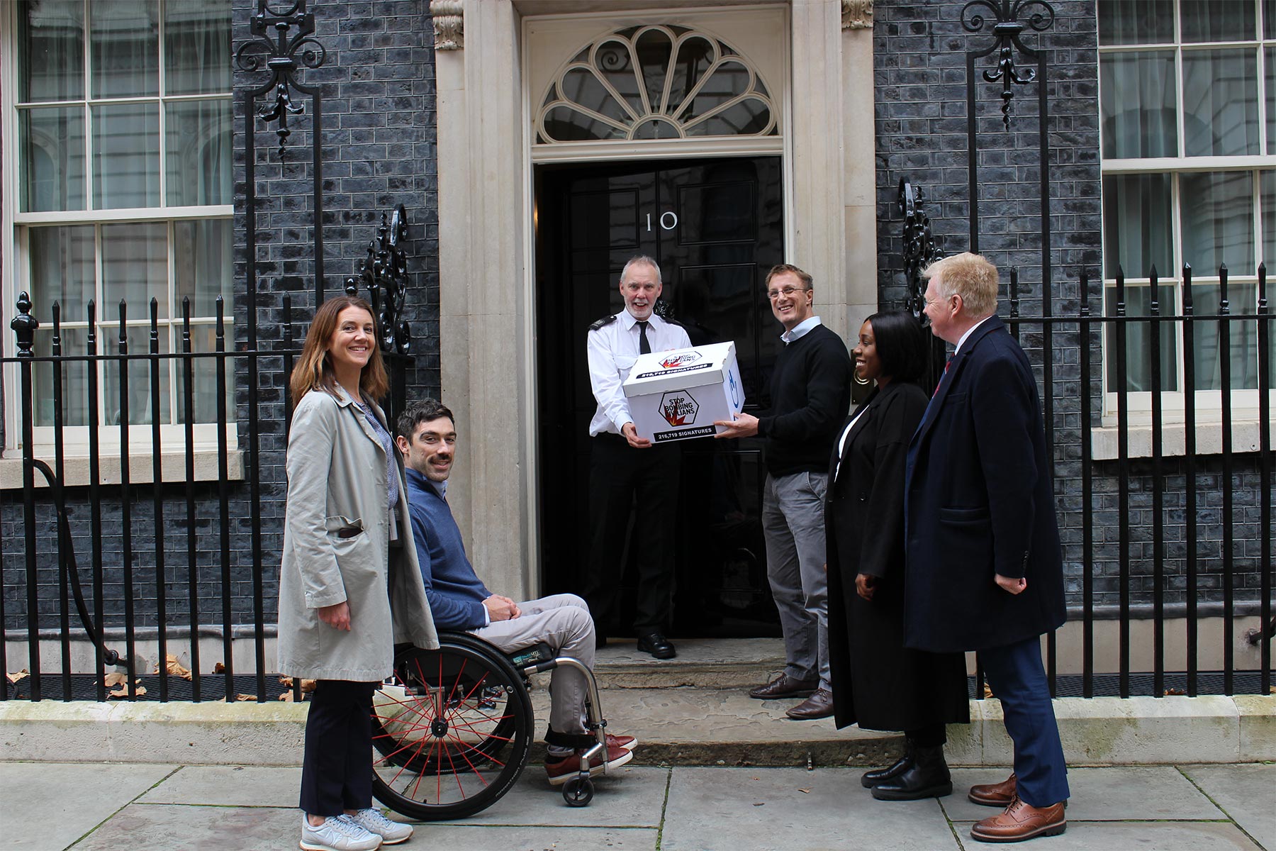 Campaigners from Humanity & Inclusion UK hand in the Stop Bombing Civilians petition at 10 Downing Street