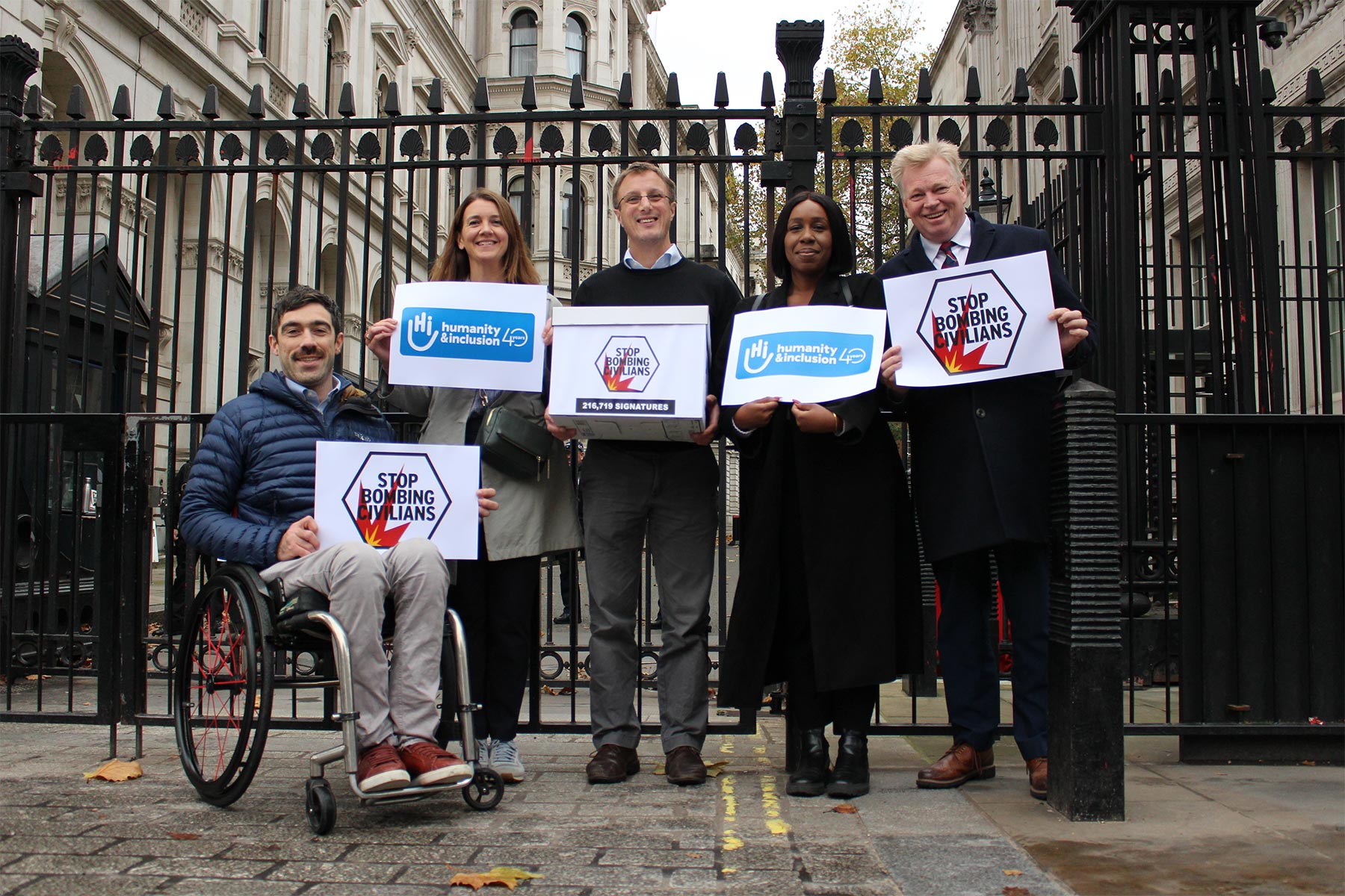 Campaigners from Humanity & Inclusion UK hand in the Stop Bombing Civilians petition at 10 Downing Street